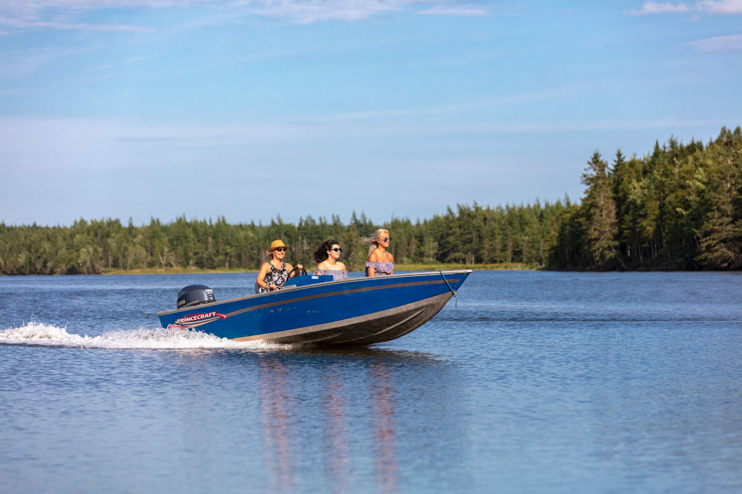 Photo shows a small motorboat with three women in bathing suits speeding along what looks like a river, from Golden Lake Estates website (screenshot September 30, 2021) advertising Nova Scotia land to German speakers for investment or a refuge.